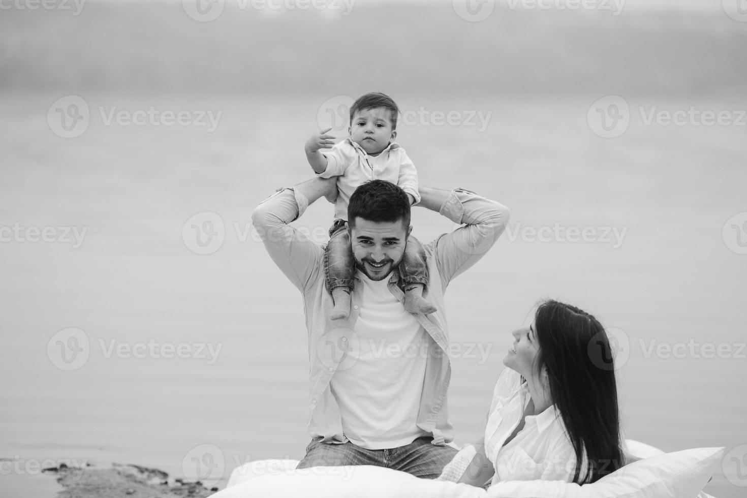 Happy young family relaxing together on the lake photo