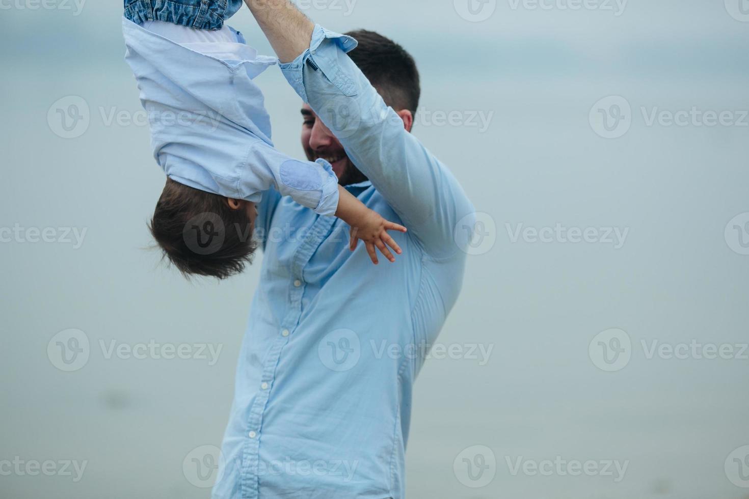 Dad holding infant son by his feet photo