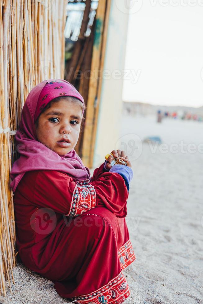 poor, sad little child girl sitting photo