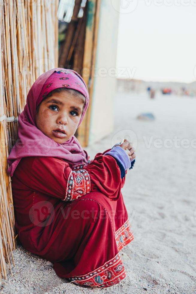 poor, sad little child girl sitting photo