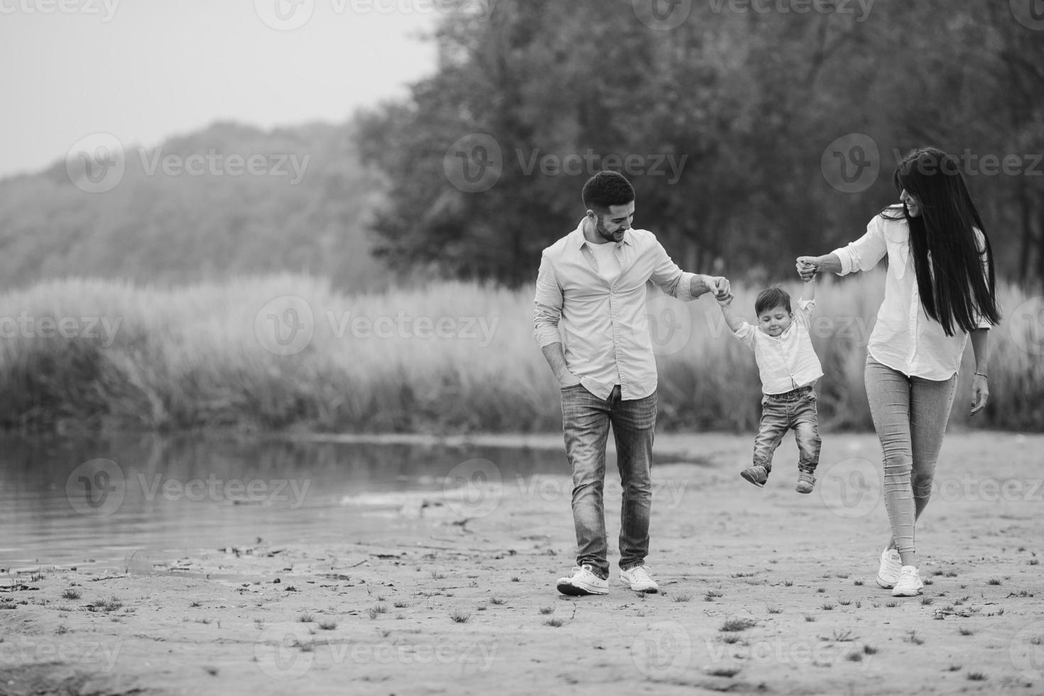 Young family walking at the beach photo