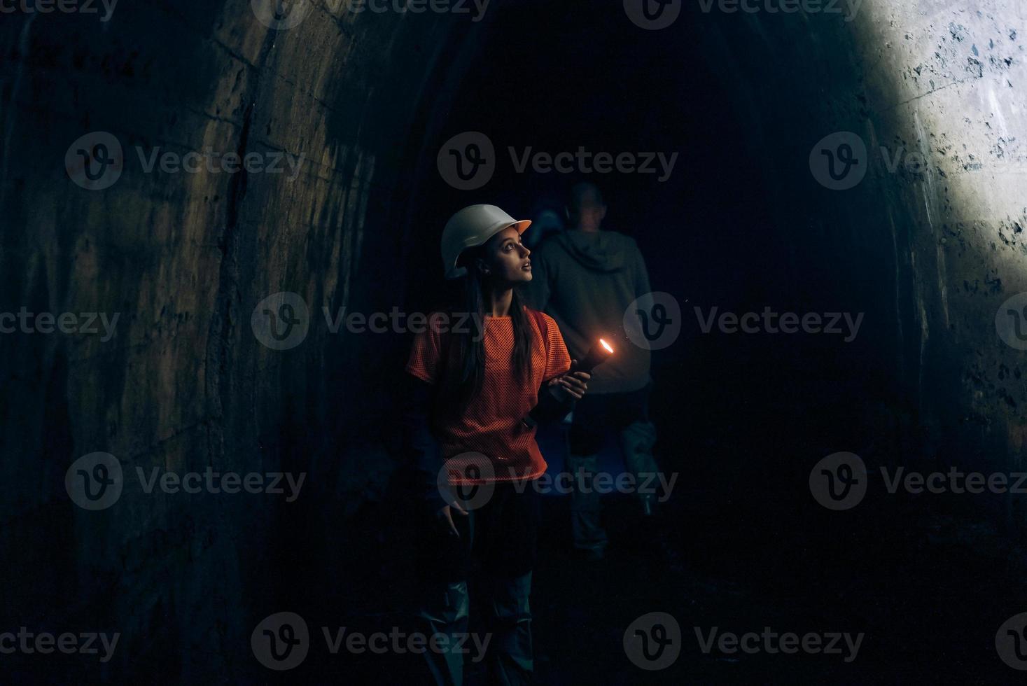 mujer excavadora con linterna explora el túnel foto