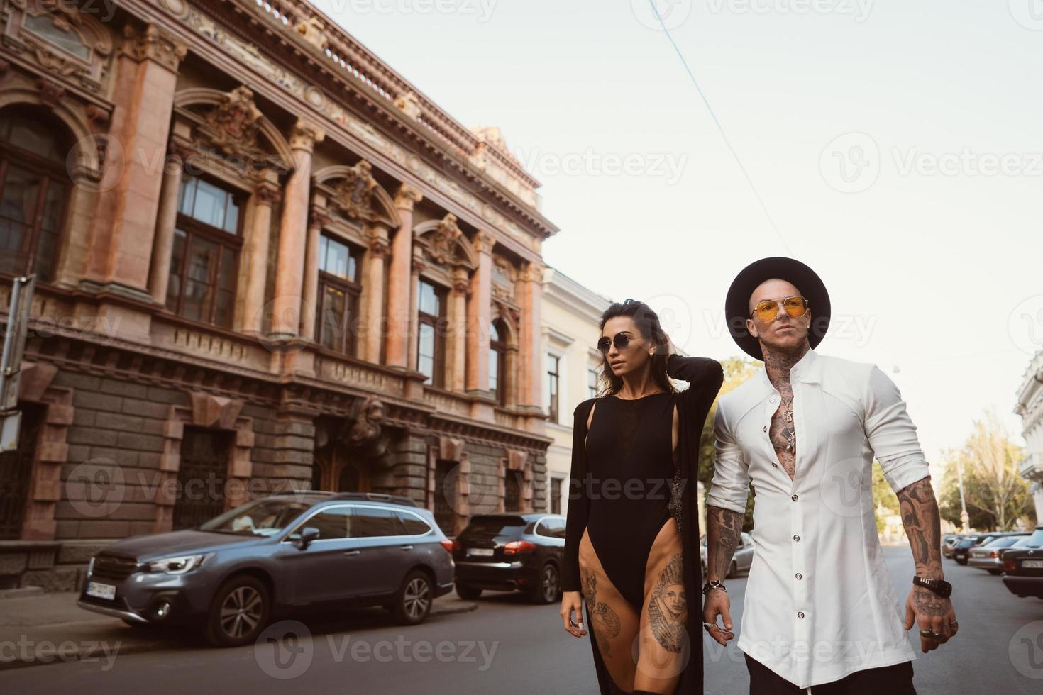 A young, sexy couple of lovers pose for a camera on the streets photo