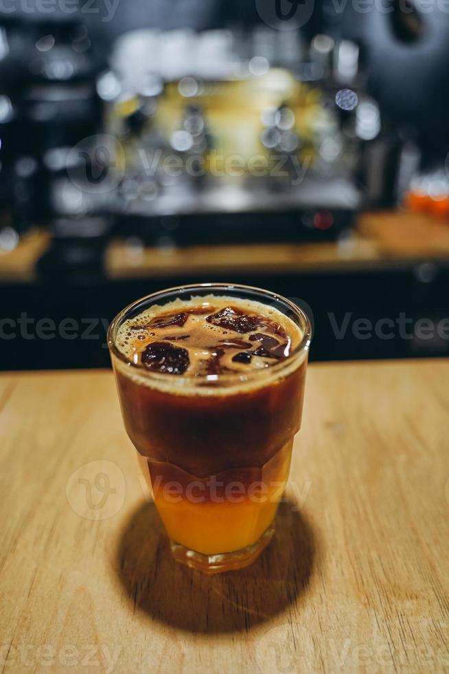 Glass with cold coffee and ice and orange. photo