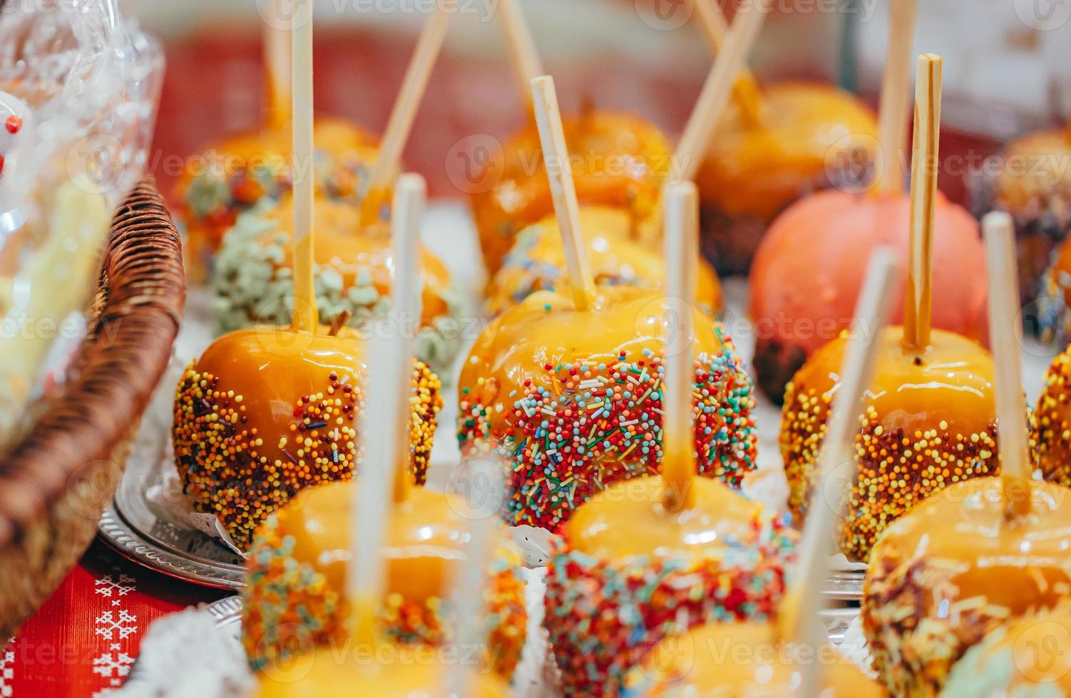 Apples in caramel and sprinkles. Street food. photo