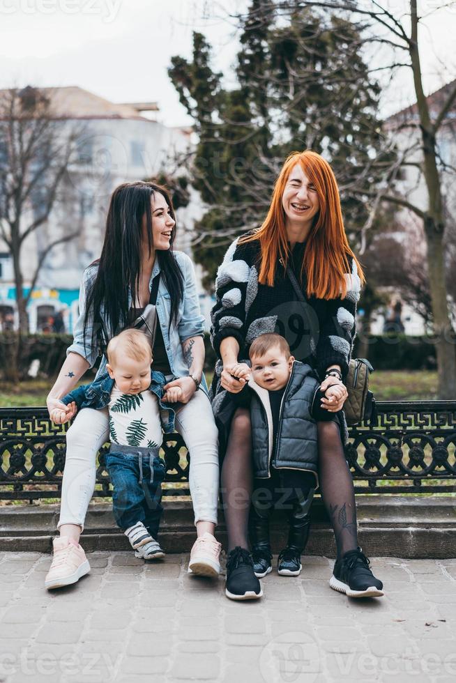 dos mamás y sus dos hijos posando en cámara foto