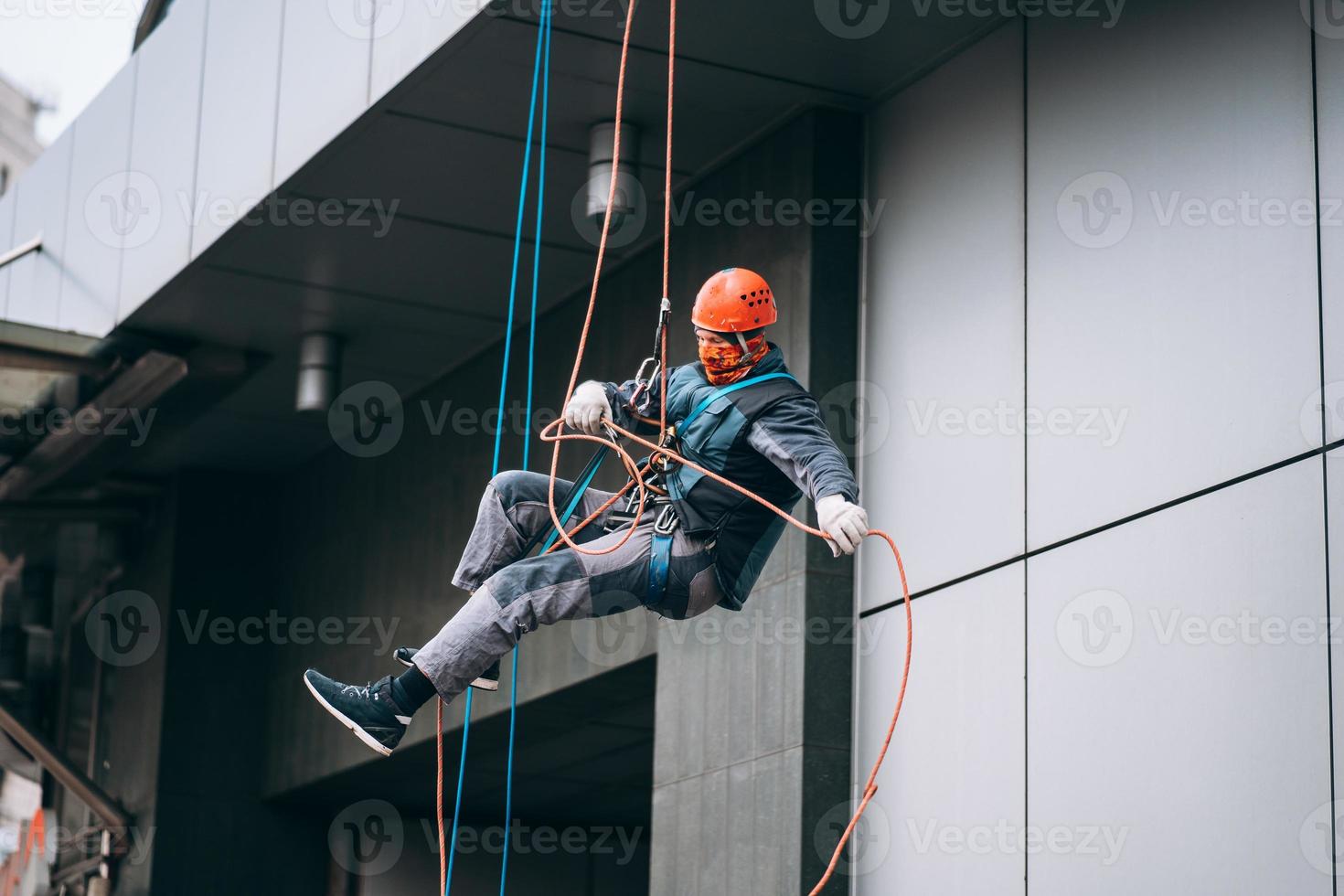 Industrial climber in uniform and helmet rises photo