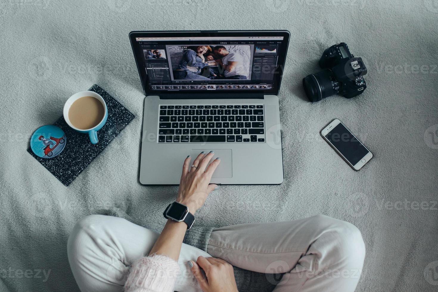 Woman using laptop on her bed photo