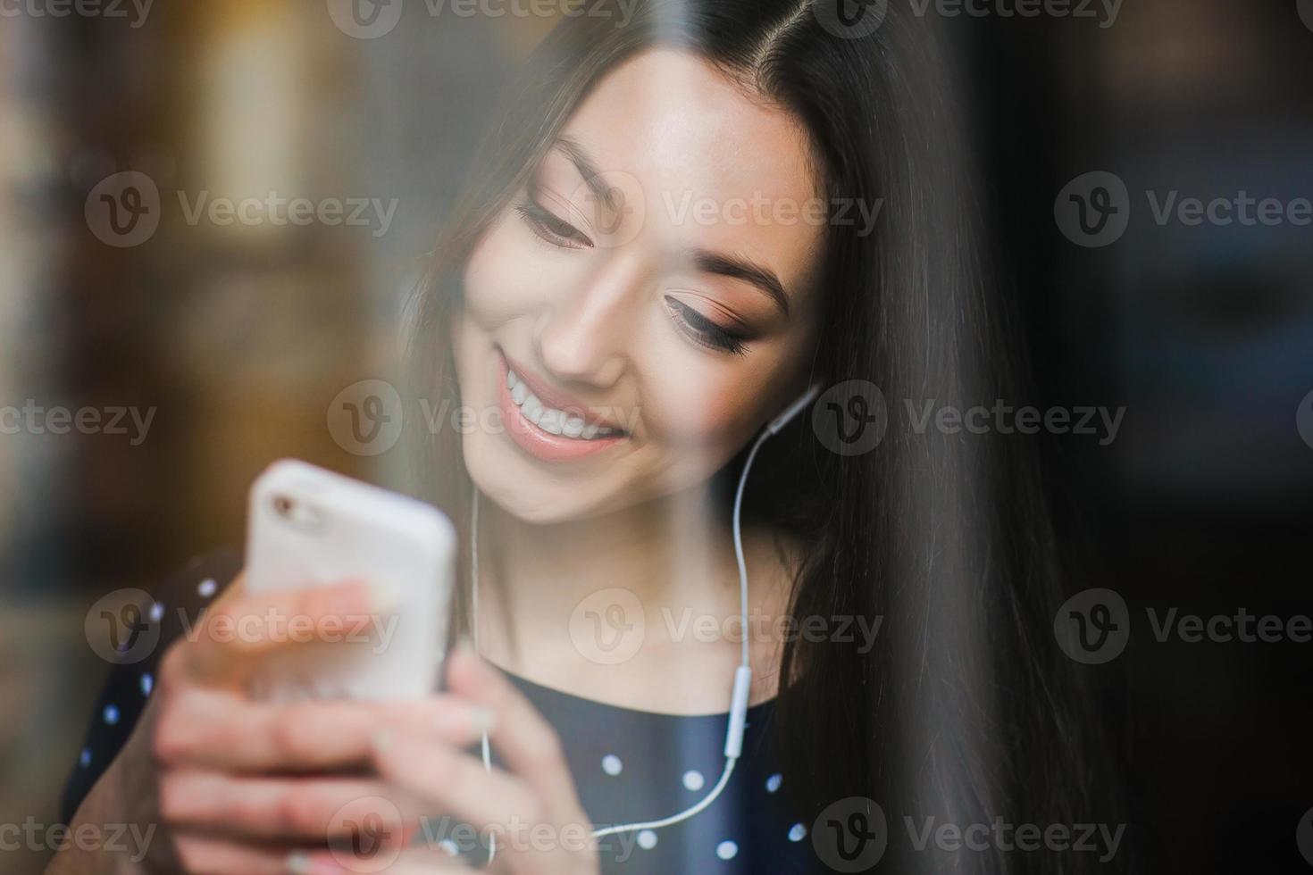 Beautiful girl listening to music on the phone with headphones photo