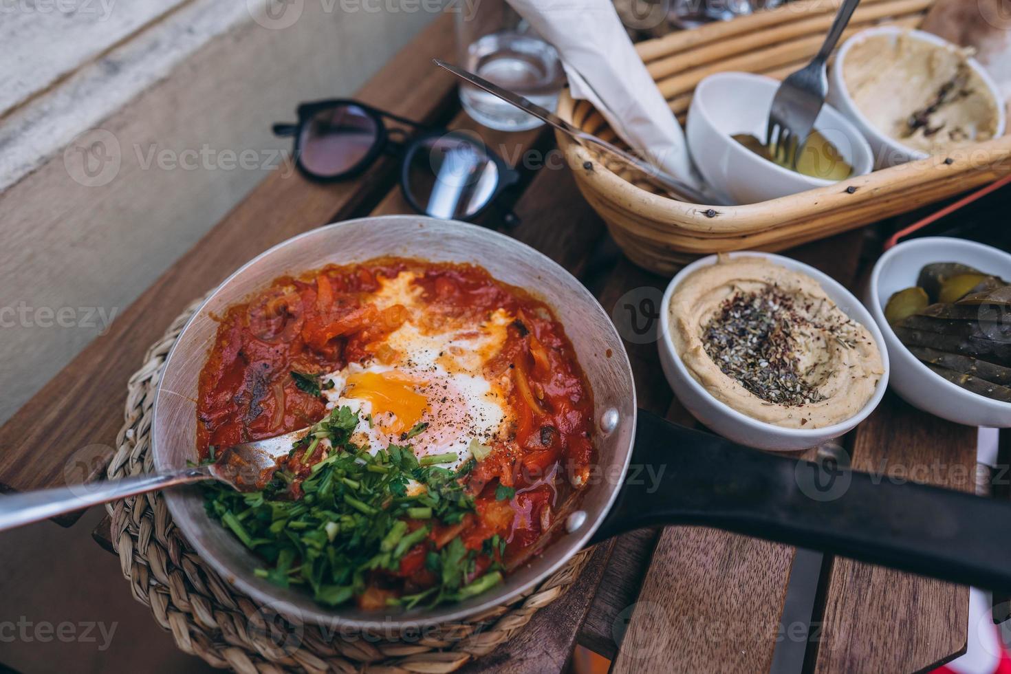 Shakshuka, Fried Eggs in Tomato Sauce on the Table photo