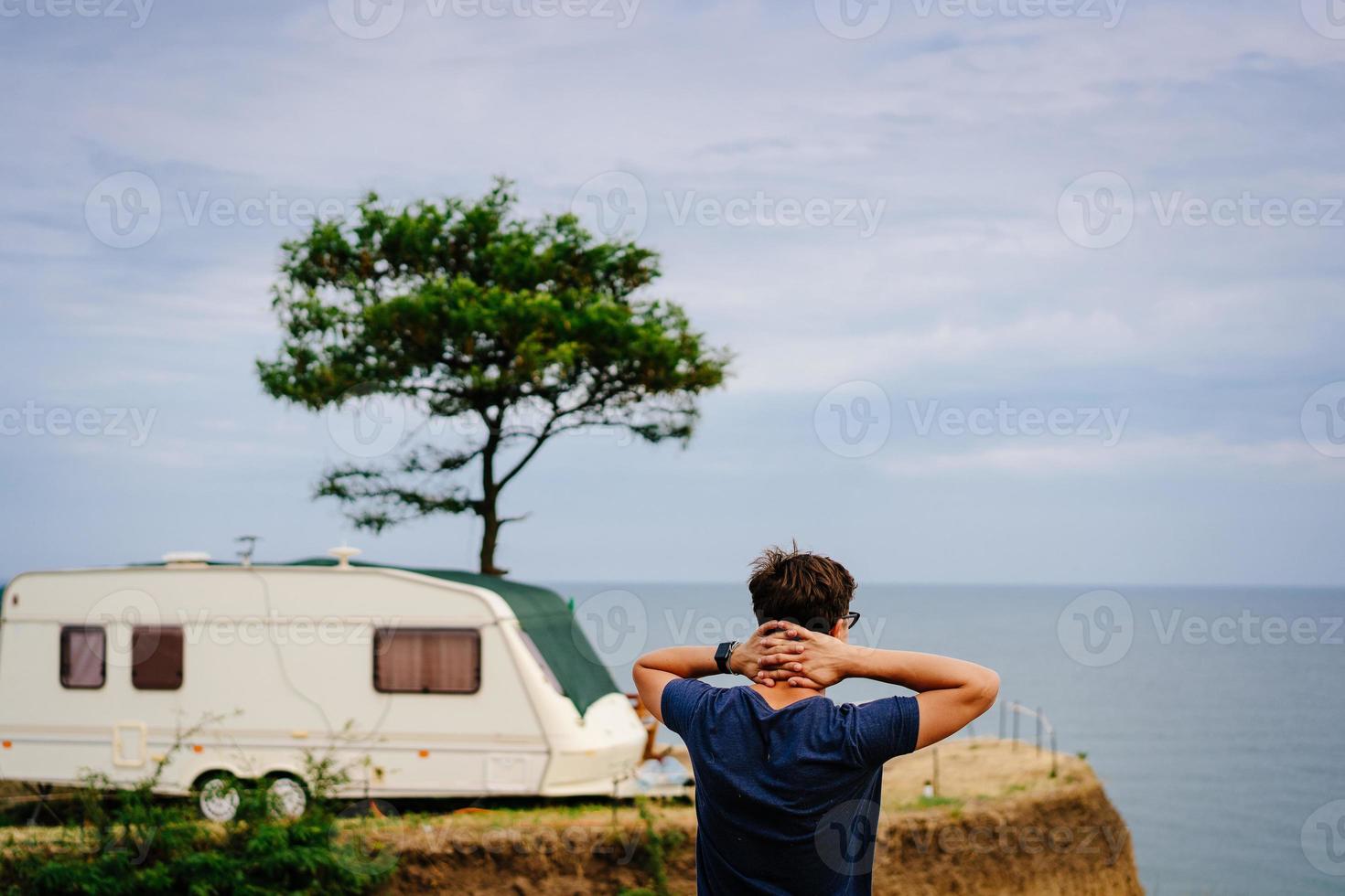 Handsome, young guy posing on a wild seashore photo