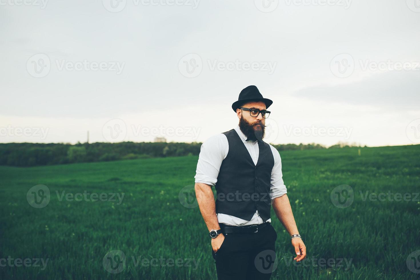 A man with a beard and sunglasses walking on the field photo