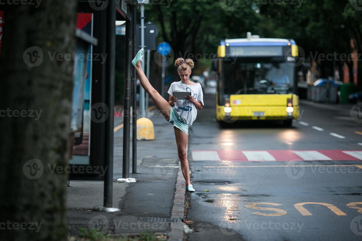 Cute girls with tablet on a bus station with a leg split photo