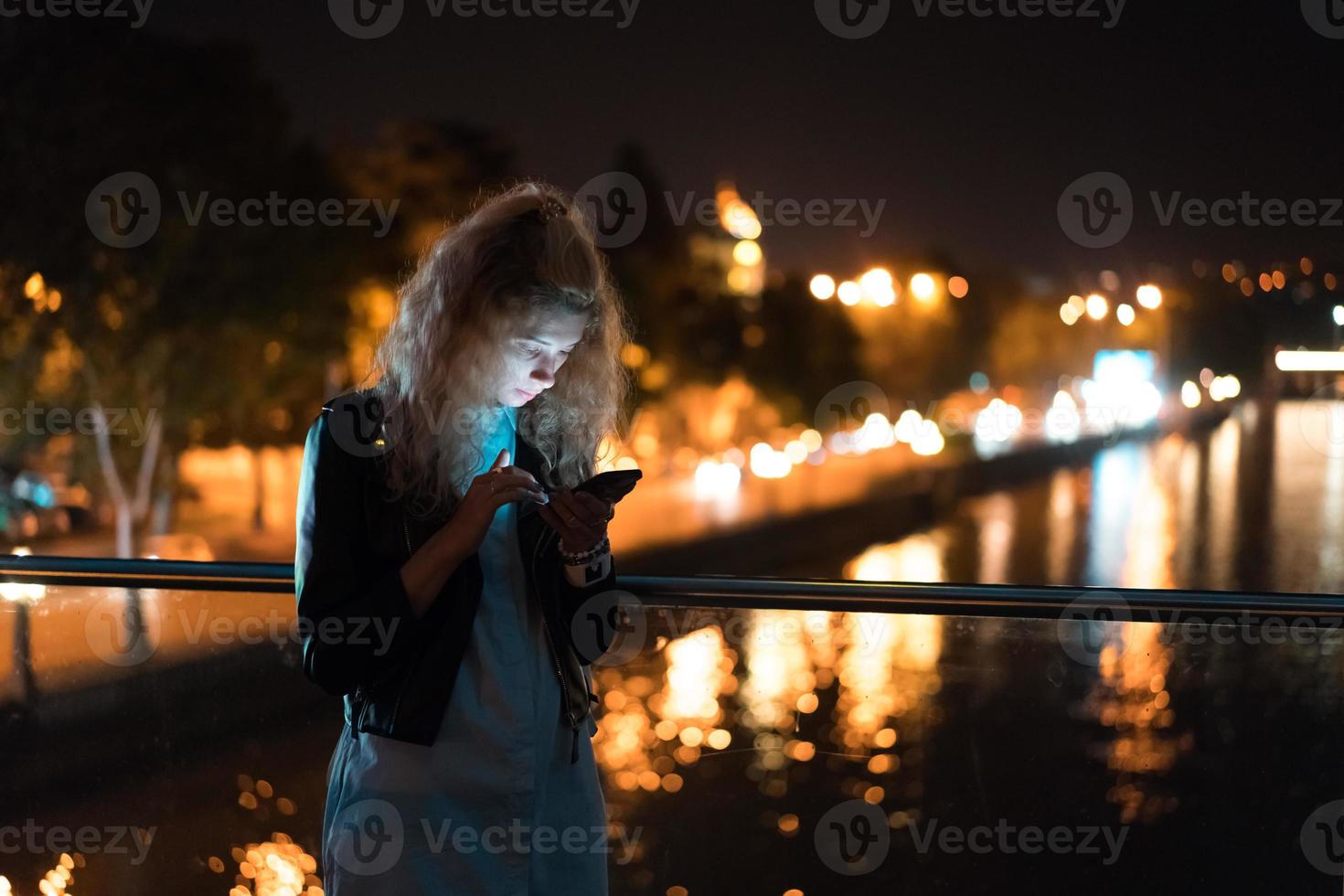 Girl with a smartphone on a bridge photo