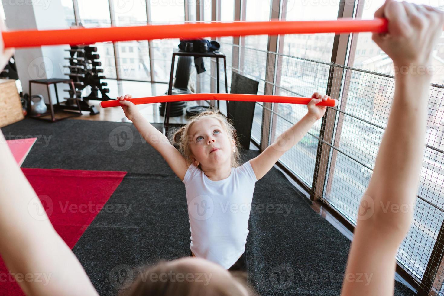 Little girl and mom doing exercises with sticks photo
