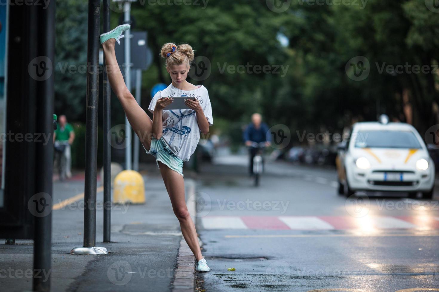 Cute girls with tablet on a bus station with a leg split photo