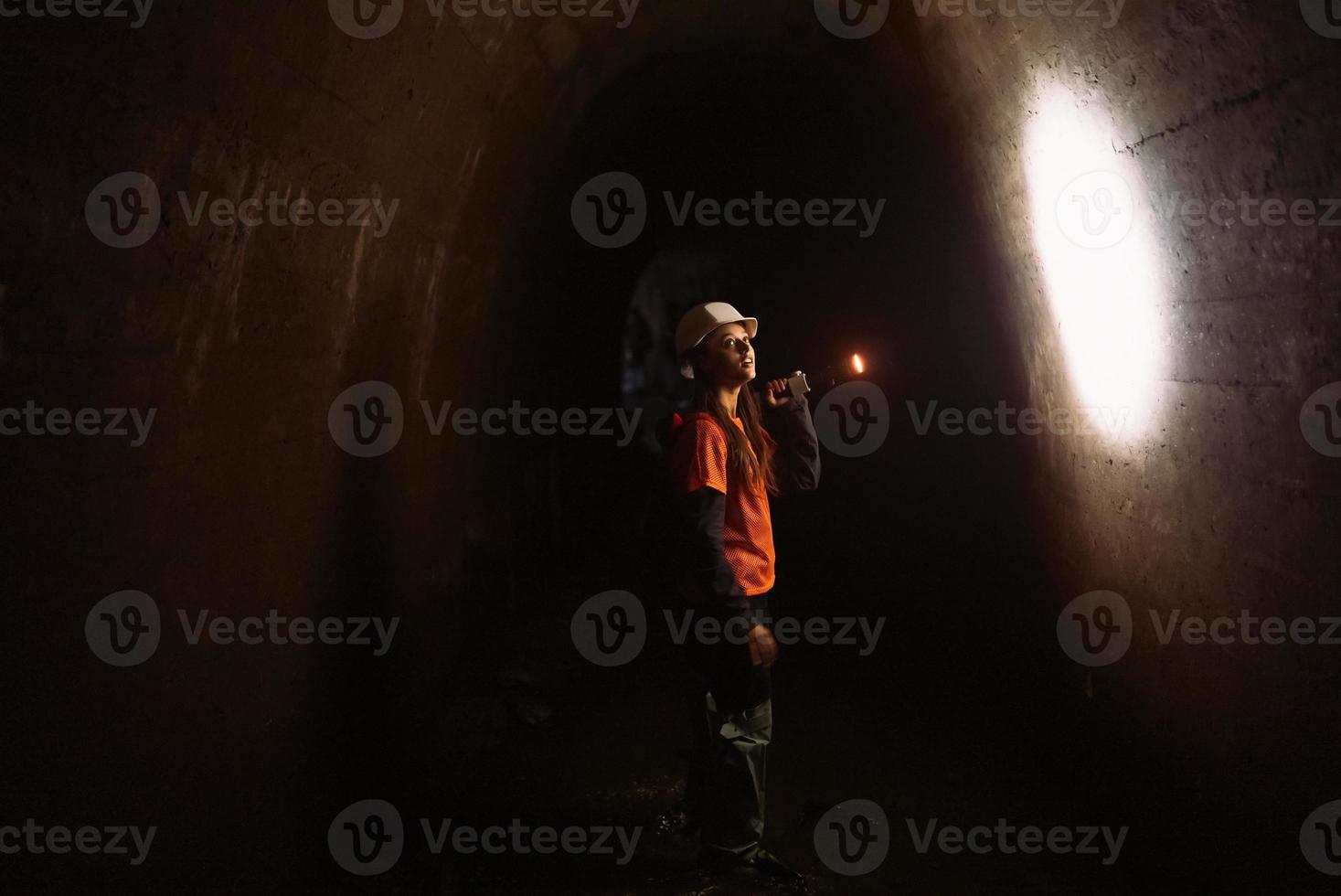 mujer excavadora con linterna explora el túnel foto