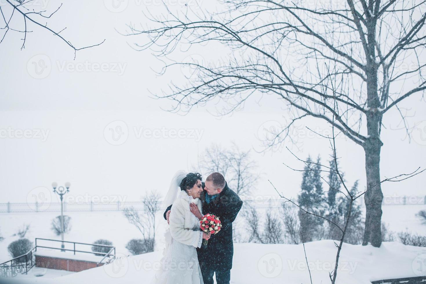 Bride and groom walking on the European city in the snow photo
