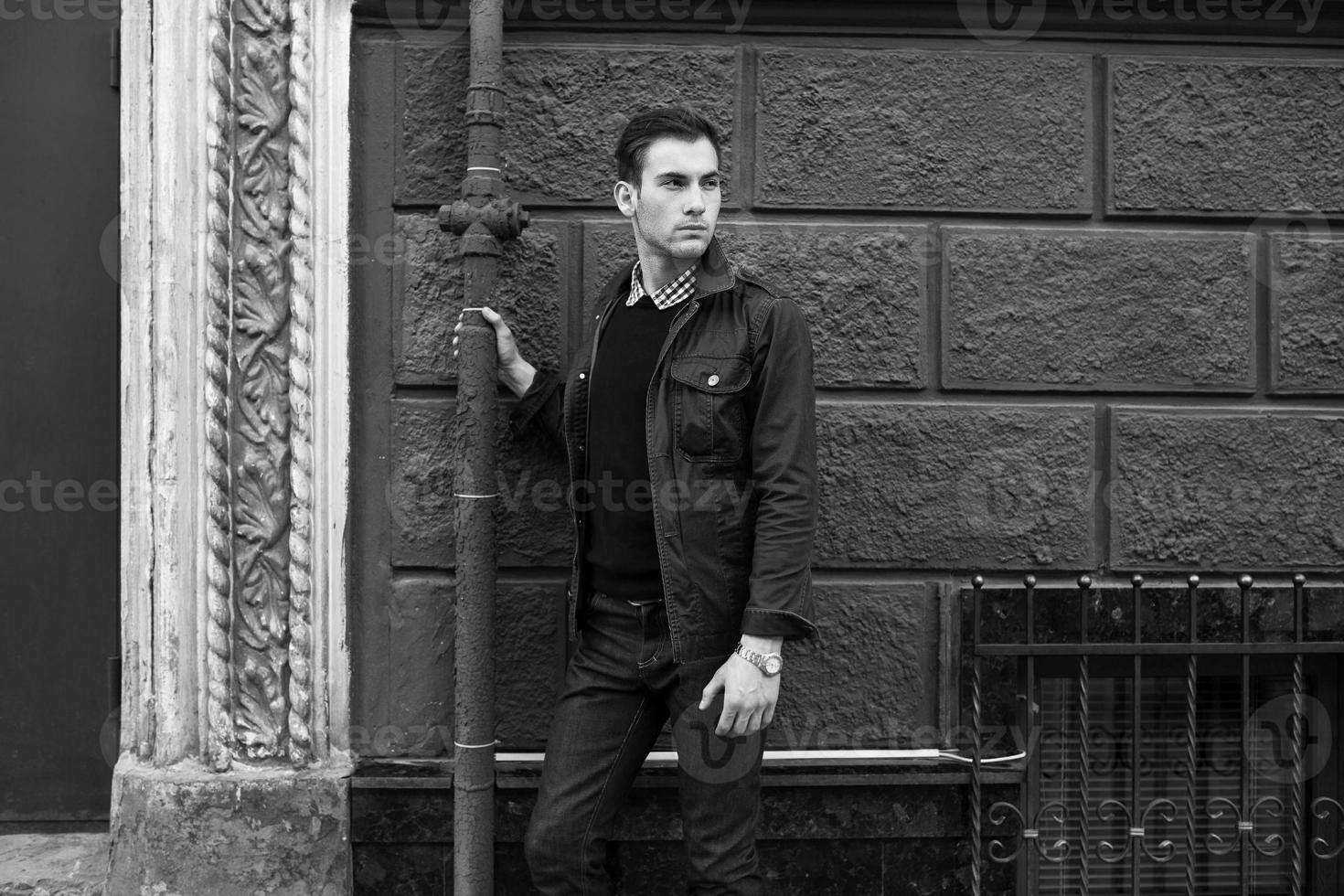 Male model in jeans on the background of a red wall photo