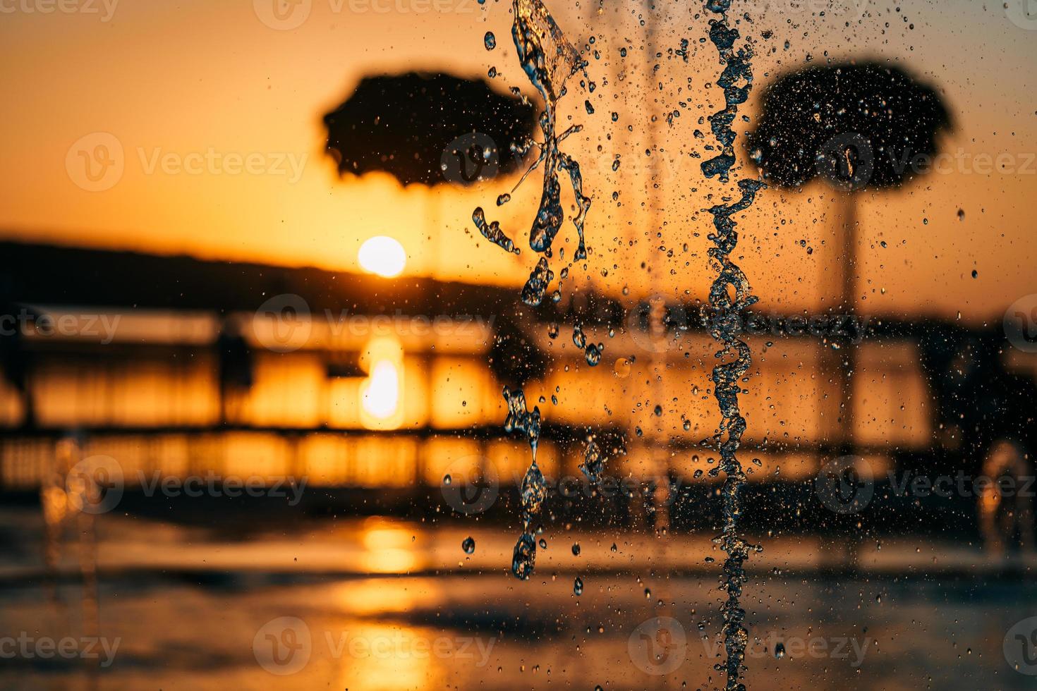 stream of a fountain splashes water, sunset photo