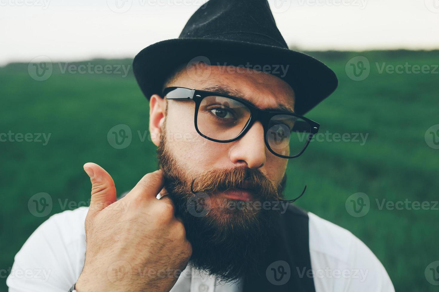 man with a beard, thinking in the field photo