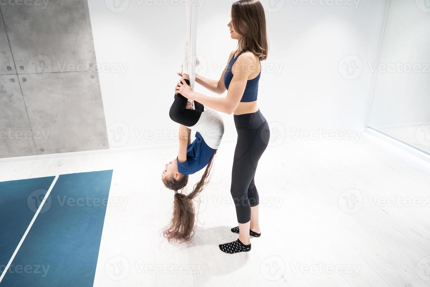 mamá e hija están haciendo yoga. familia en un gimnasio. foto