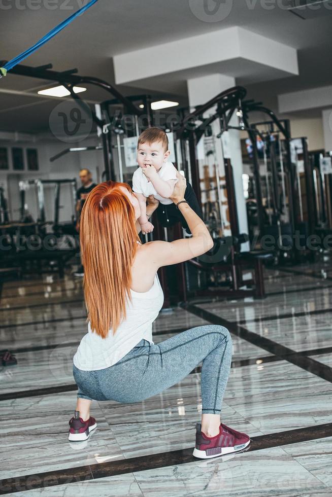 joven madre con su hijo pequeño en el gimnasio foto