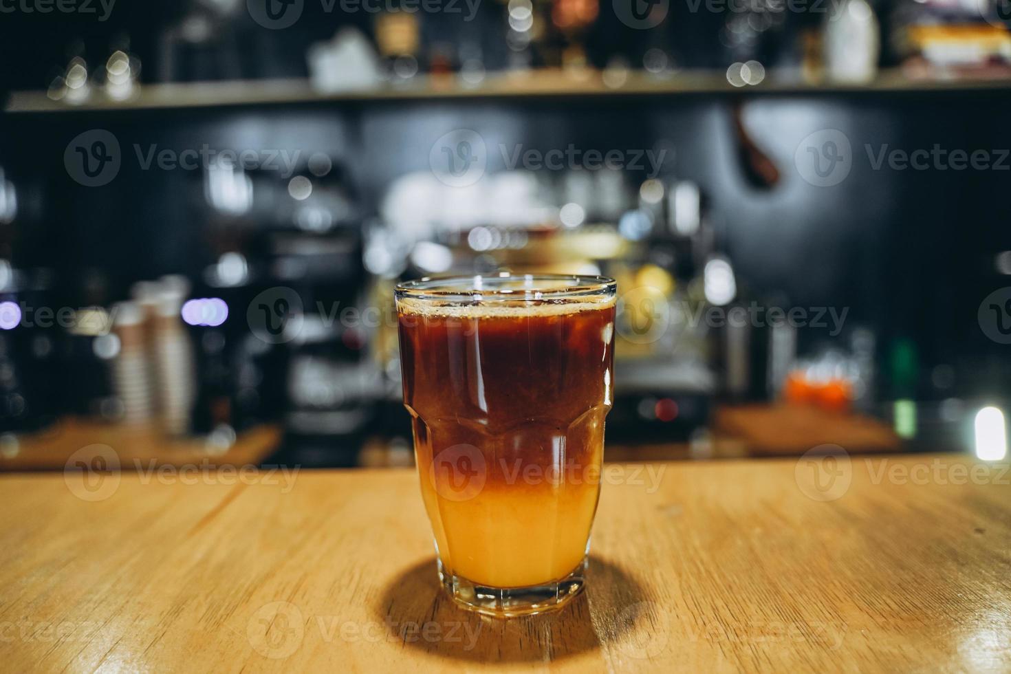 Glass with cold coffee and ice and orange. photo