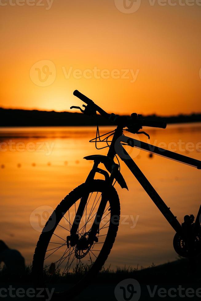 bicicleta en el fondo de una puesta de sol foto