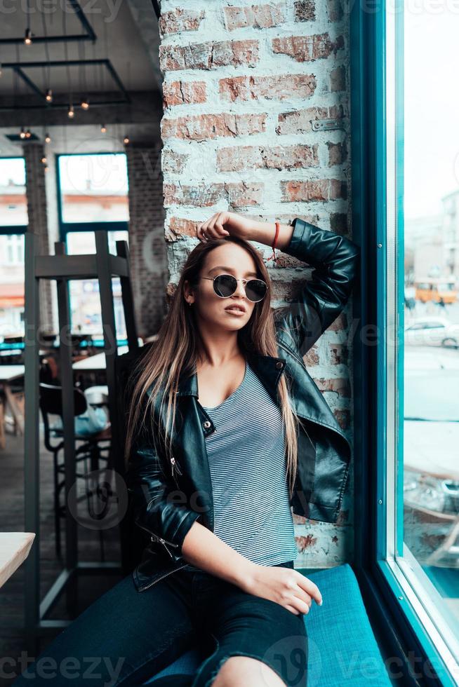 hermosa chica con gafas de sol posando en la cámara foto