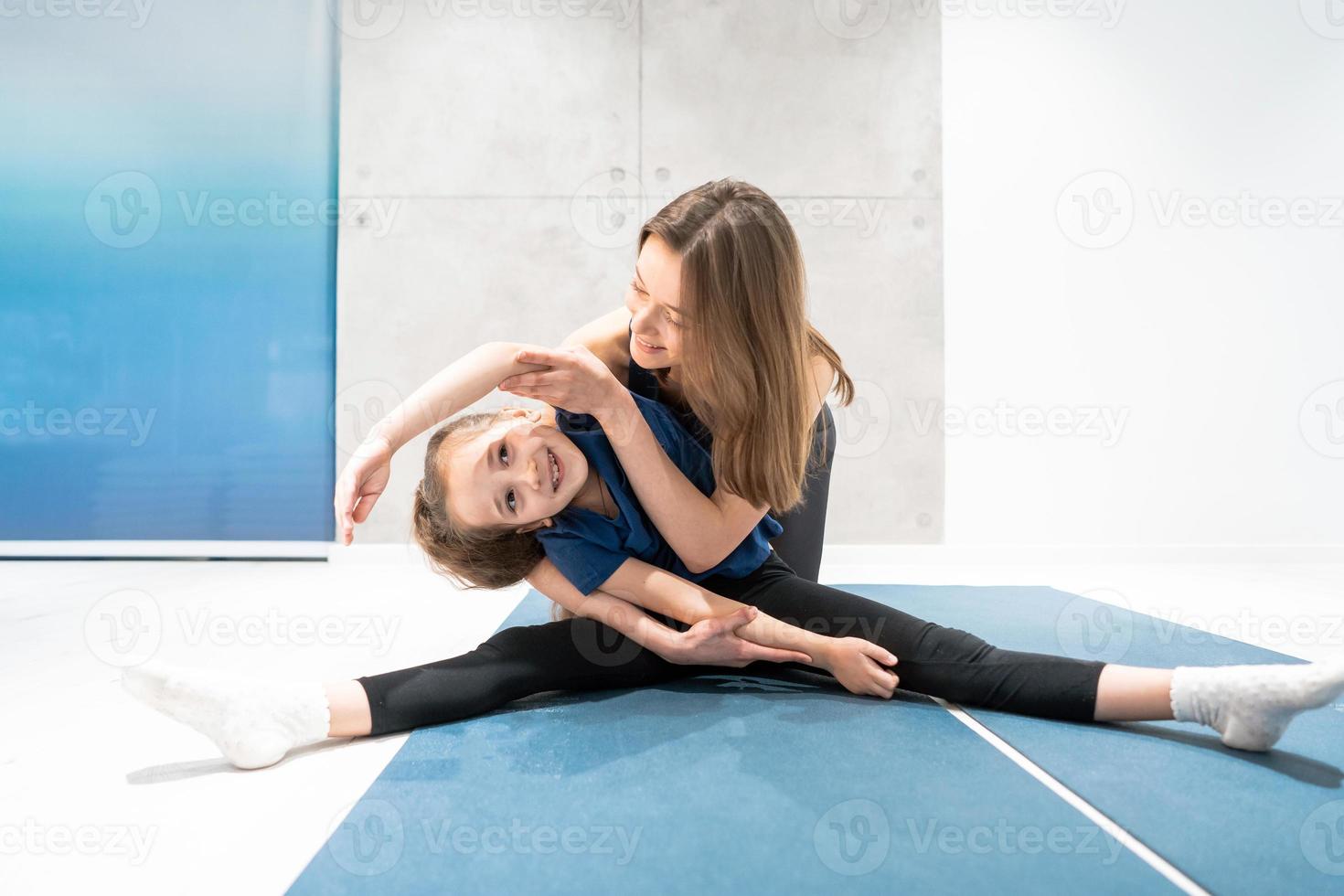 Mom and daughter do stretching before exercise photo