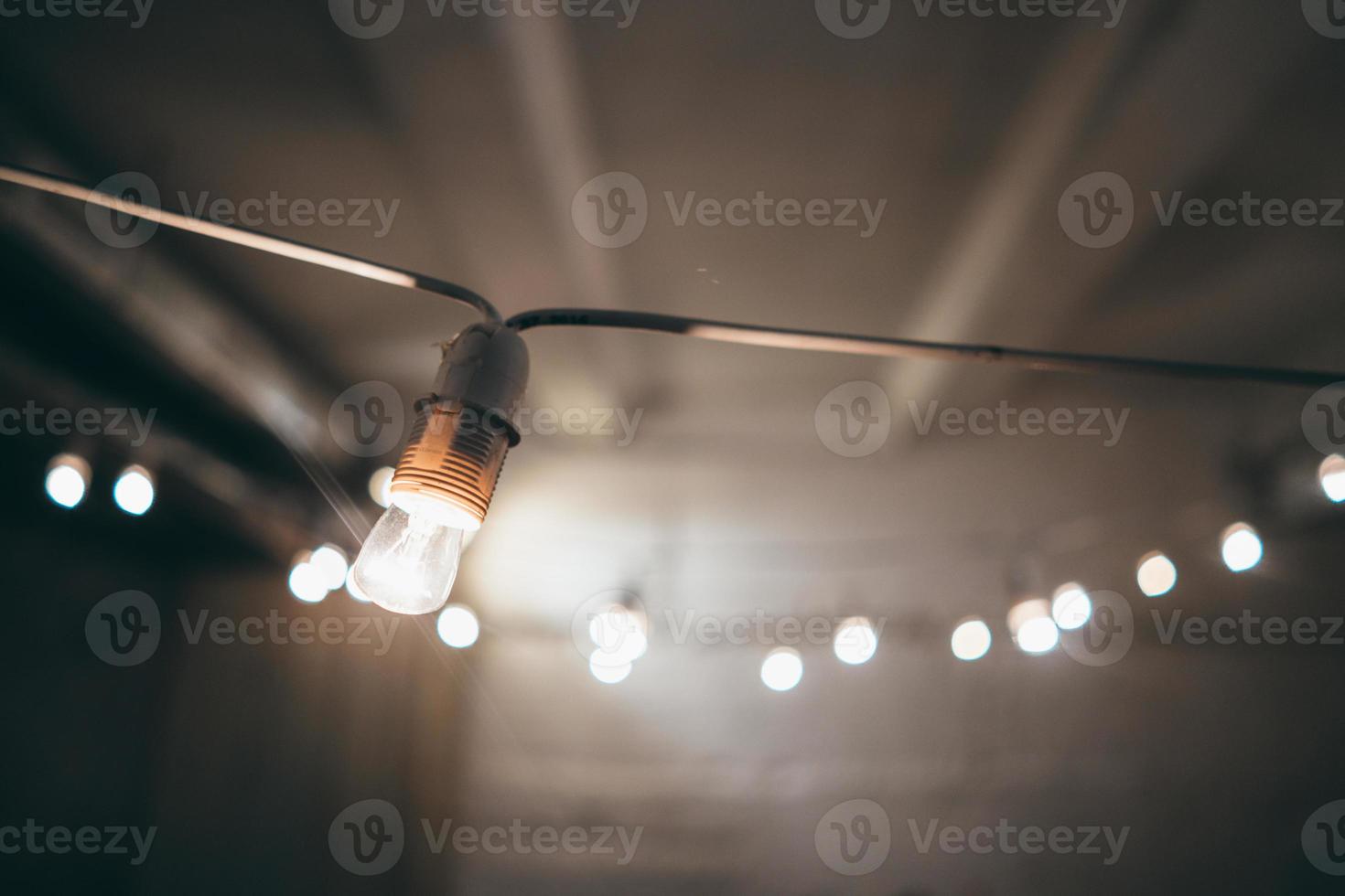 Lamp on garland with lights on background photo