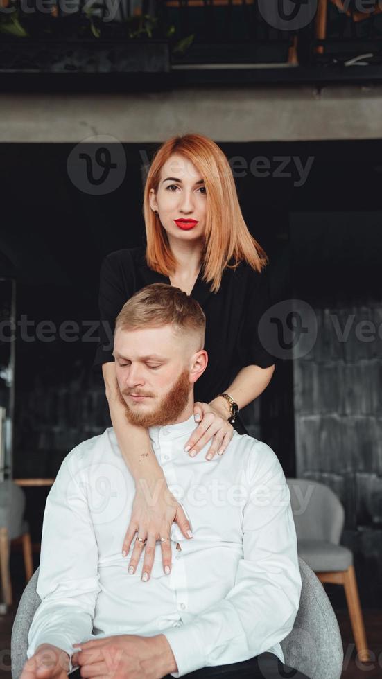 A young woman and her boyfriend are posing for the camera indoors. photo