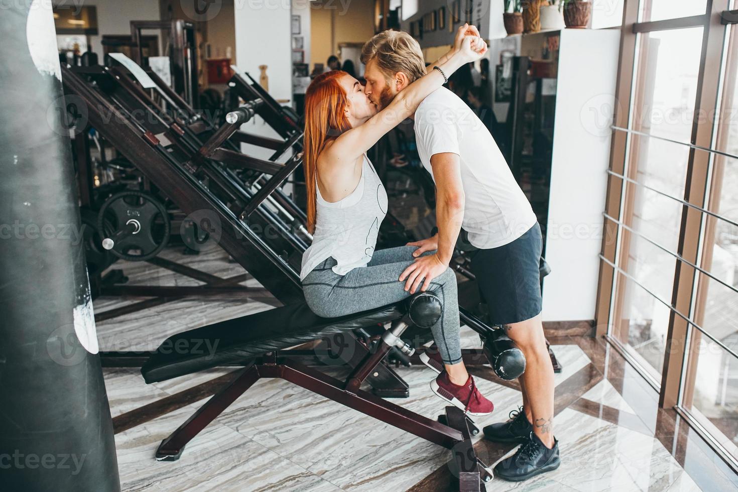 guy kiss girlfriend on training in gym photo