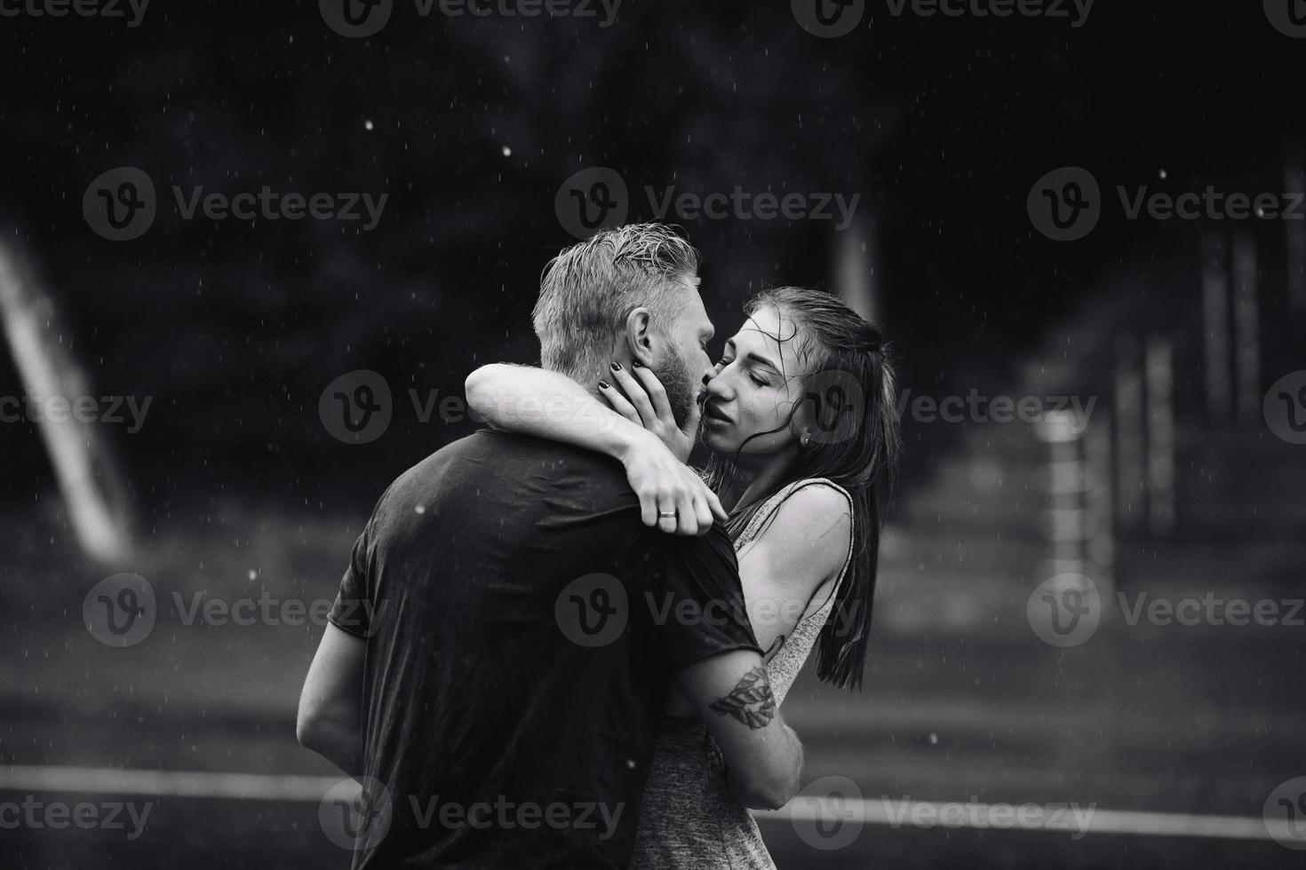 beautiful couple kissing  in the rain photo