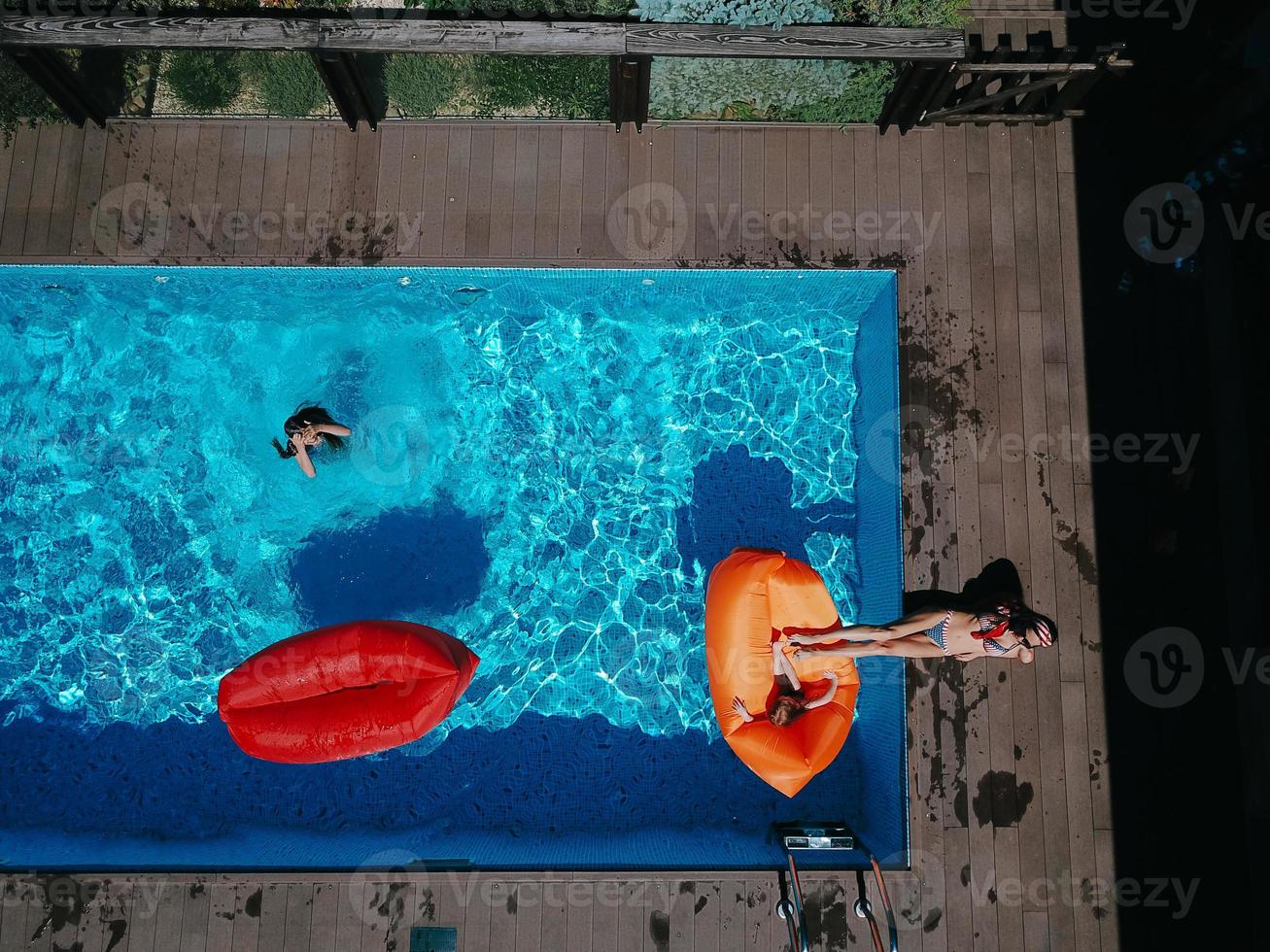 mamá e hijas descansan en la piscina. foto