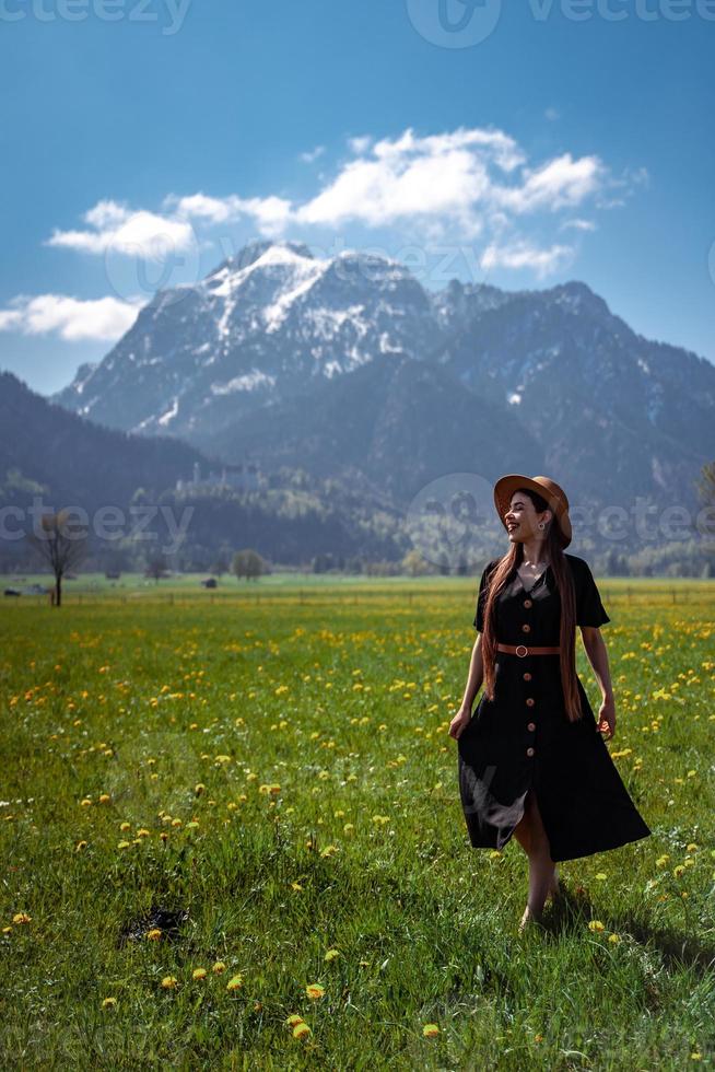 Beautiful girl in dress and hat on meadow in mountains. photo