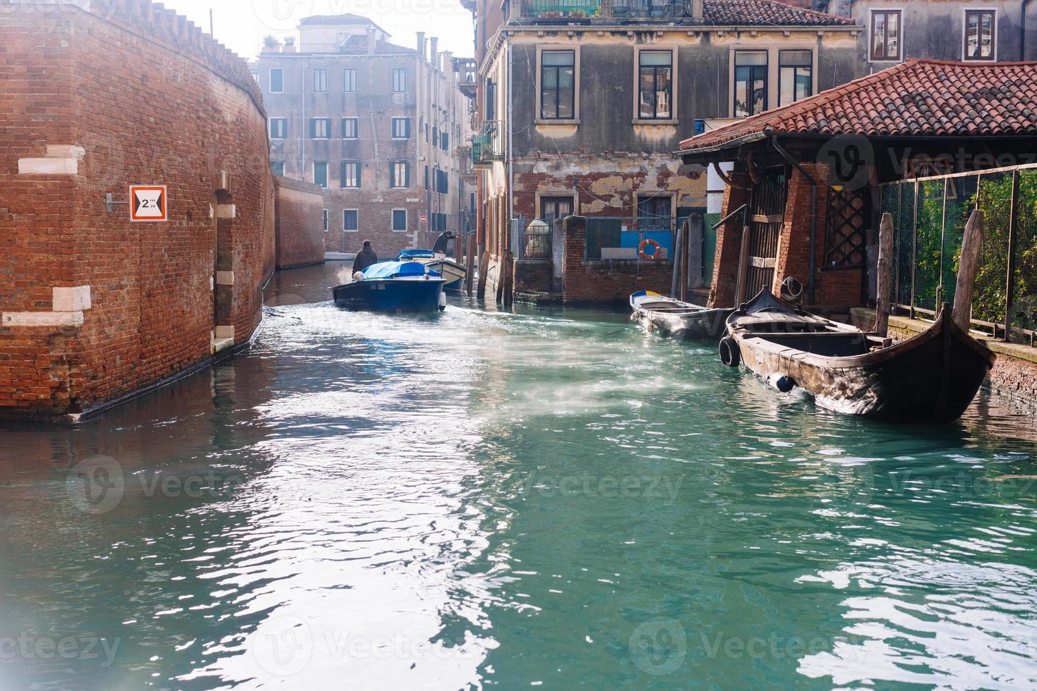 canal veneciano con casas antiguas y barcos foto