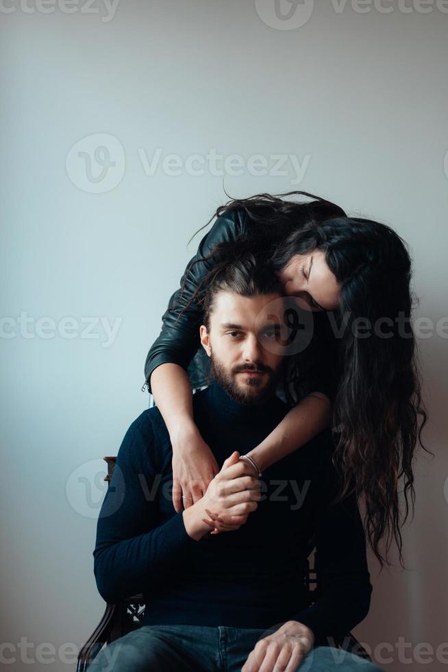 Guy sitting on a chair, girl standing behind him photo