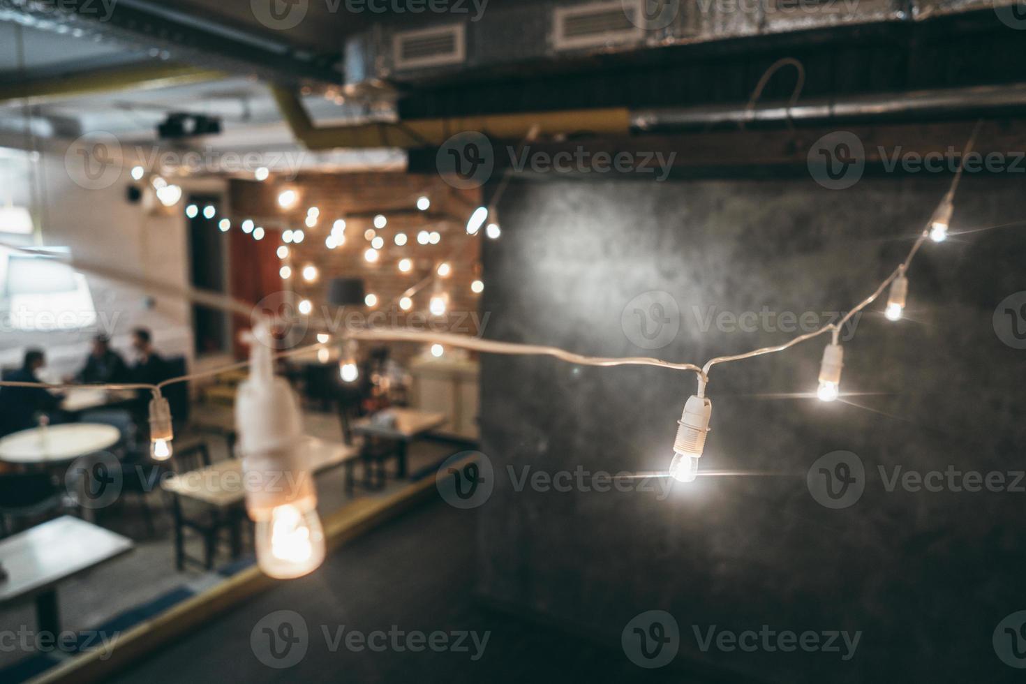 Lamp on garland with lights on background photo