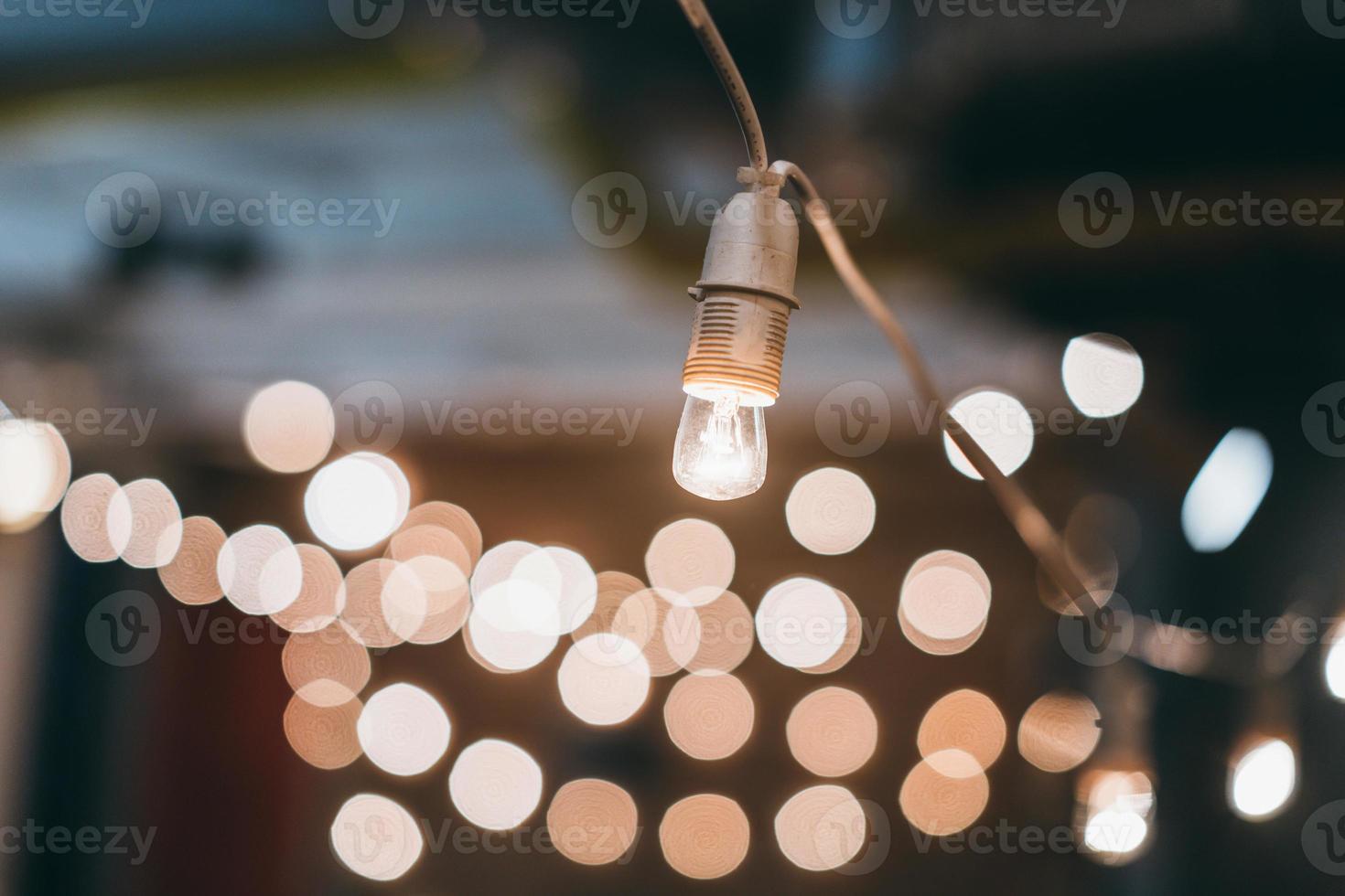 Lamp on garland with lights on background photo