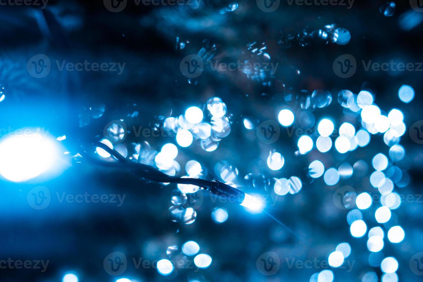 Christmas tree with cones on a city street illuminated with a garland. photo