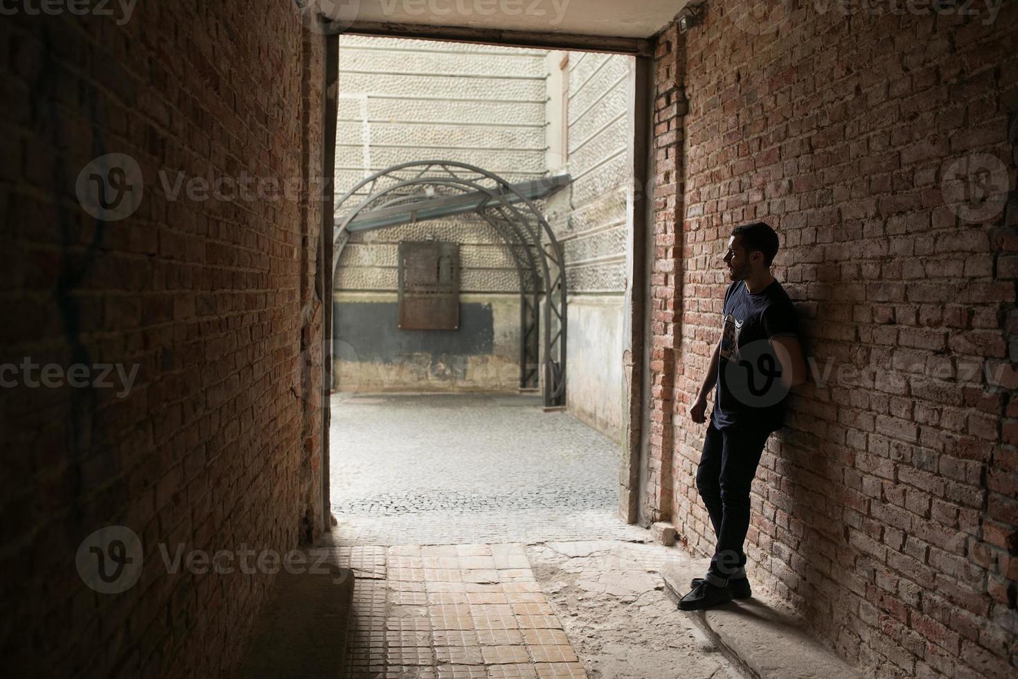 The man in the authentic boots and selvedge jeans  on a background of old city photo