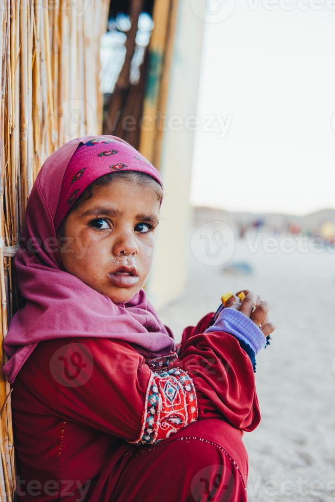 poor, sad little child girl sitting photo