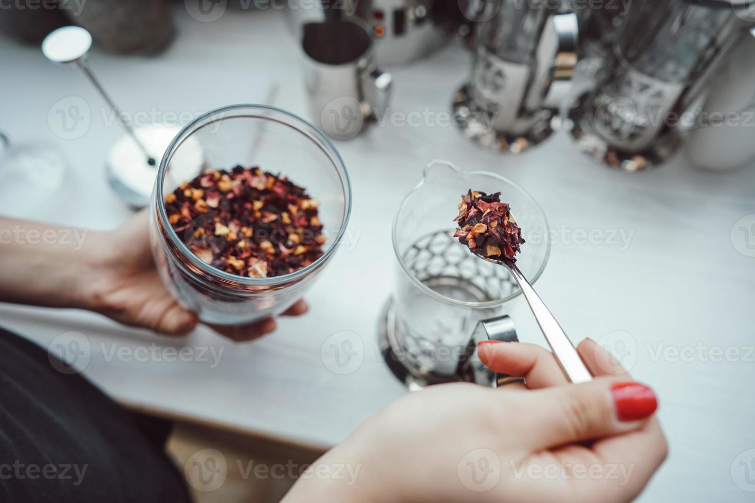 Pour dry tea leaves into the glass container of the tea press maker photo