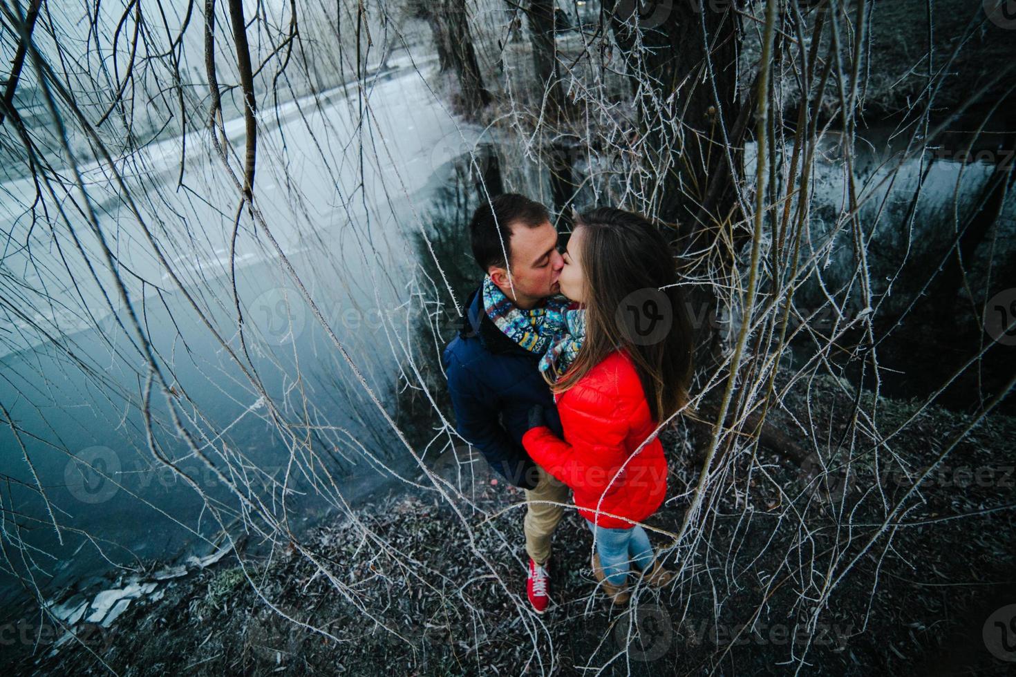 hermosa pareja posando cerca de un río congelado foto