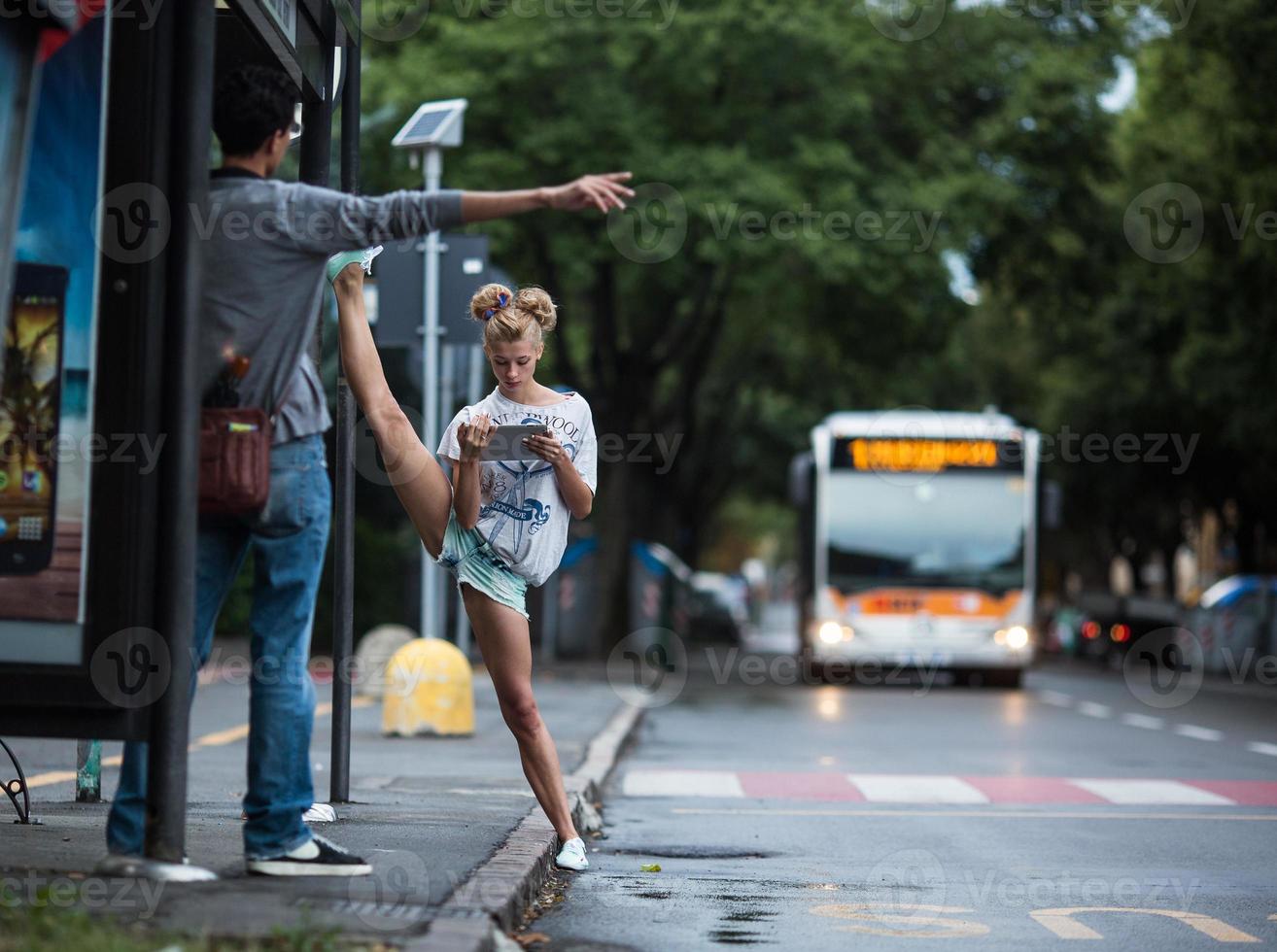 Cute girls with tablet on a bus station with a leg split photo