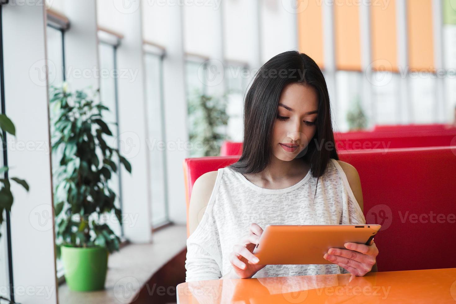 Beautiful girl working on a tablet and smiling photo