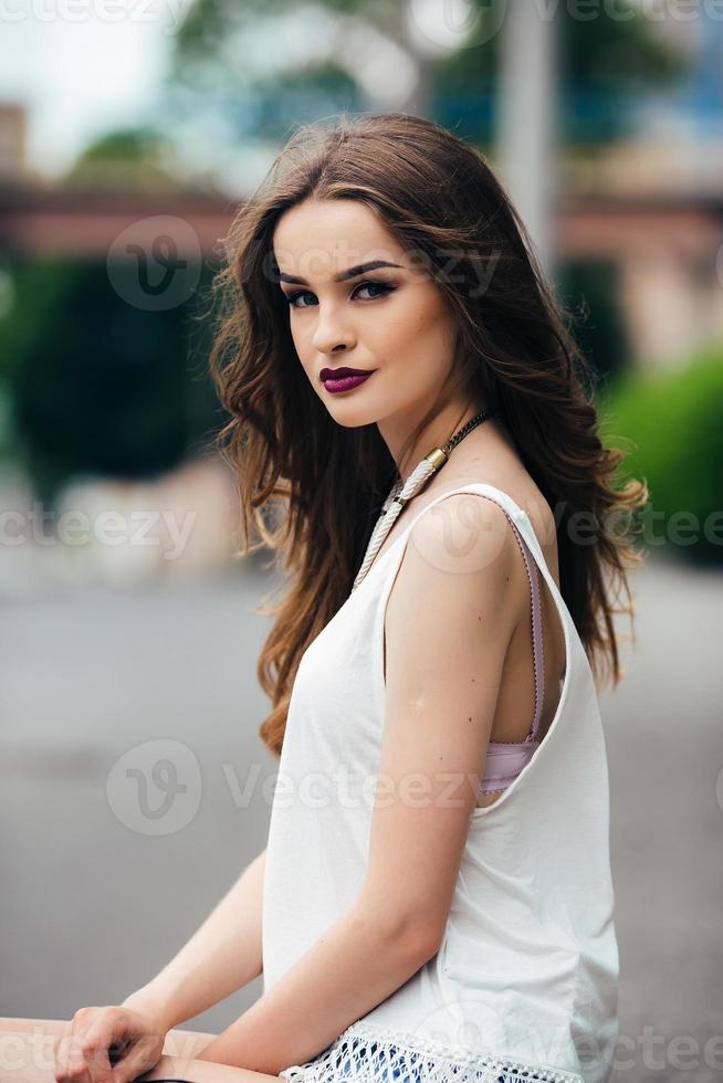 pretty girl sitting in a city street photo