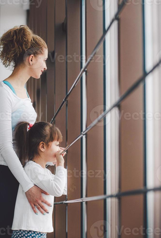 dos chicas de diferentes edades miran fijamente por una ventana en el gimnasio foto